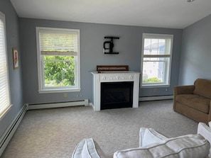 A living room with a fireplace, two windows, and a brown couch. - Between the beaches extended family retreat-Gourmet Kitchen (York)