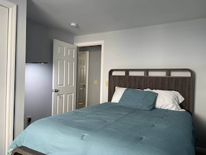 A bedroom with a bed, a door, and a light switch on the wall. - Between the beaches extended family retreat-Gourmet Kitchen (York)