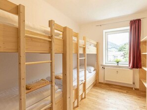 A bunk bed room with a window and radiator.