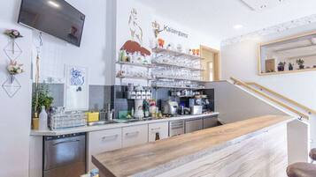 A modern kitchen with a wooden countertop, stainless steel appliances, and a mounted television.