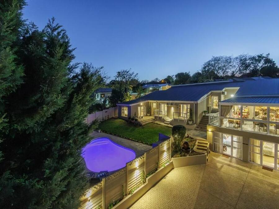 Una propiedad residencial con piscina, varios niveles y un exterior bien iluminado.