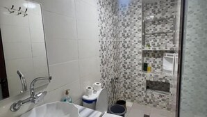 A bathroom with a white sink, toilet, and shower area. - Olea Azul (chefchaouen)