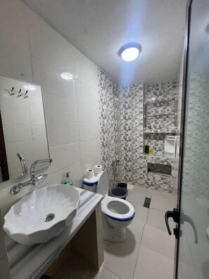 A bathroom with a white sink, toilet, and shower area. - Olea Azul (chefchaouen)