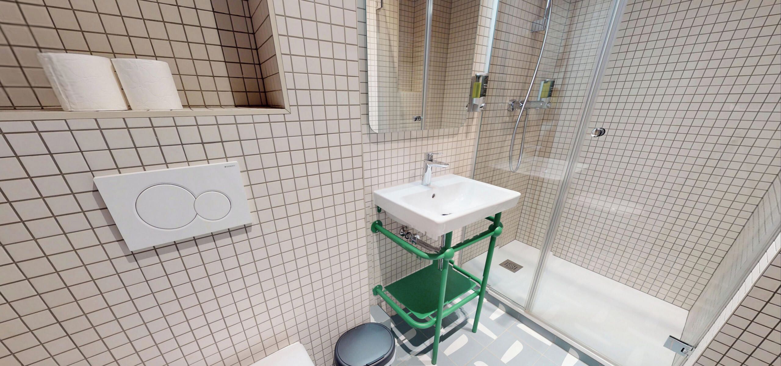 A modern bathroom with a shower, toilet, and a sink.