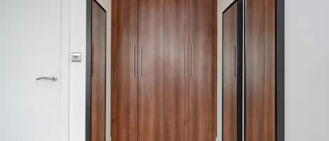 A hallway with a wooden wardrobe, a door, and a mirror.