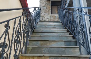 Un escalier avec des marches en pierre et des rampes en métal.