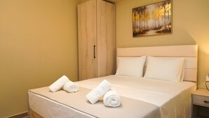 Habitación de hotel con cama, armario, un cuadro en la pared y mesita de noche.