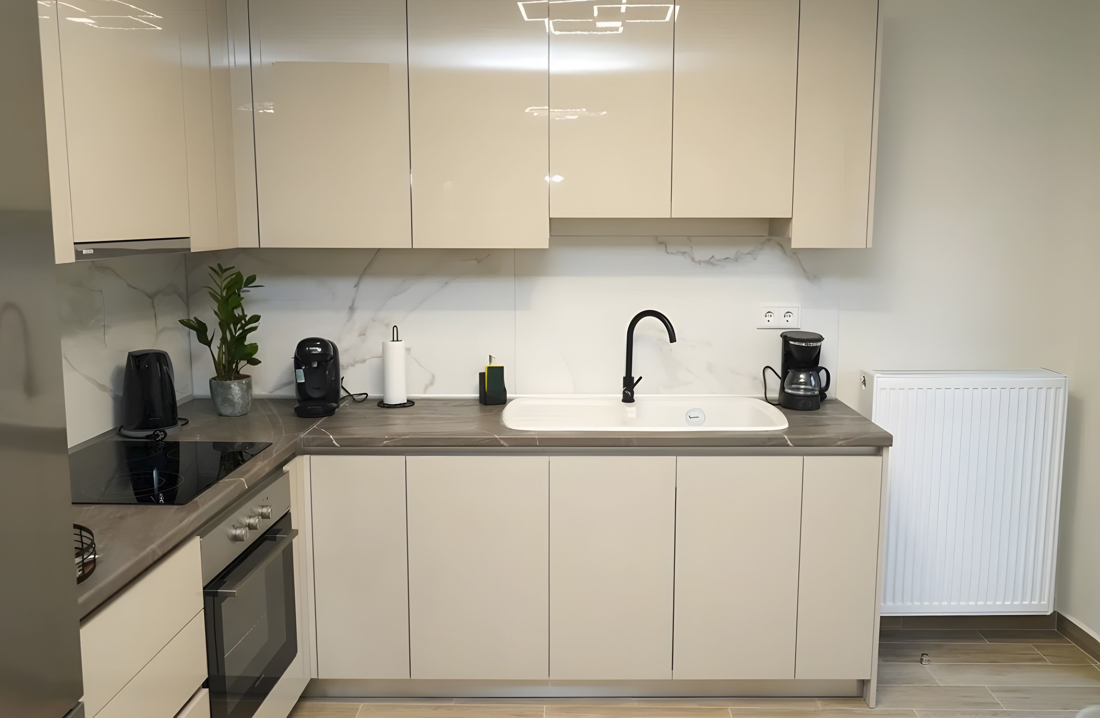 Una cocina moderna con una isla central, horno empotrado y campana extractora.