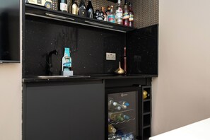 Eine Minibar mit einer Auswahl an Spirituosenflaschen und einem Flaschenöffner.