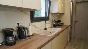 Una cocina moderna con un lavamanos integrado, una cafetera y un hervidor.