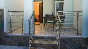Una escalera con barandas de metal que lleva a un cuarto con una mesa de comedor y sillas.