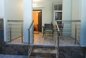 Un escalier avec des rampes en métal menant à une pièce où se trouvent une table à manger et des chaises.