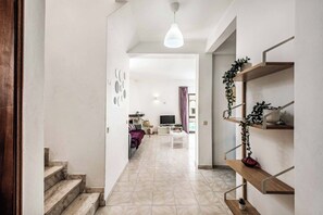 A modern interior with a staircase, a dining area, and a living space with a TV and seating. - Villa Lanzarote - Four Bedroom Villa, Sleeps 8 (Albufeira)