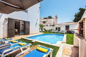 Una piscina amb gandules i una zona de barbacoa.