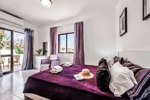 A bedroom with a bed, a desk, a chair, and a window with curtains. - Villa Lanzarote - Four Bedroom Villa, Sleeps 8 (Albufeira)