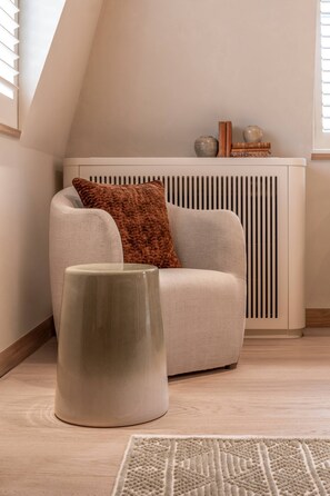 A modern living room with a sofa, a decorative stool, and a radiator. - Cadogan Street IV by onefinestay (London)