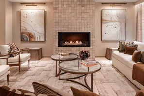 A modern living room with a fireplace, two sofas, a coffee table, and abstract art on the walls. - Cadogan Street IV by onefinestay (London)
