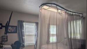 A bedroom with a bed, a desk with a chair, a window with blinds, and a ceiling fan. - 146-6 Dizzy Gillespe Upper-Level Retreat 2Gather Self		1 Bedroom Studio. (New London)