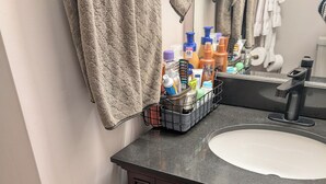 A bathroom with a dark wood vanity, a white sink, and a towel rack with a beige towel. - 146-6 Dizzy Gillespe Upper-Level Retreat 2Gather Self		1 Bedroom Studio. (New London)