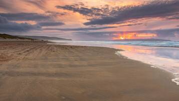 Una platja amb un capvespre, mar tranquil·la i cel serè.