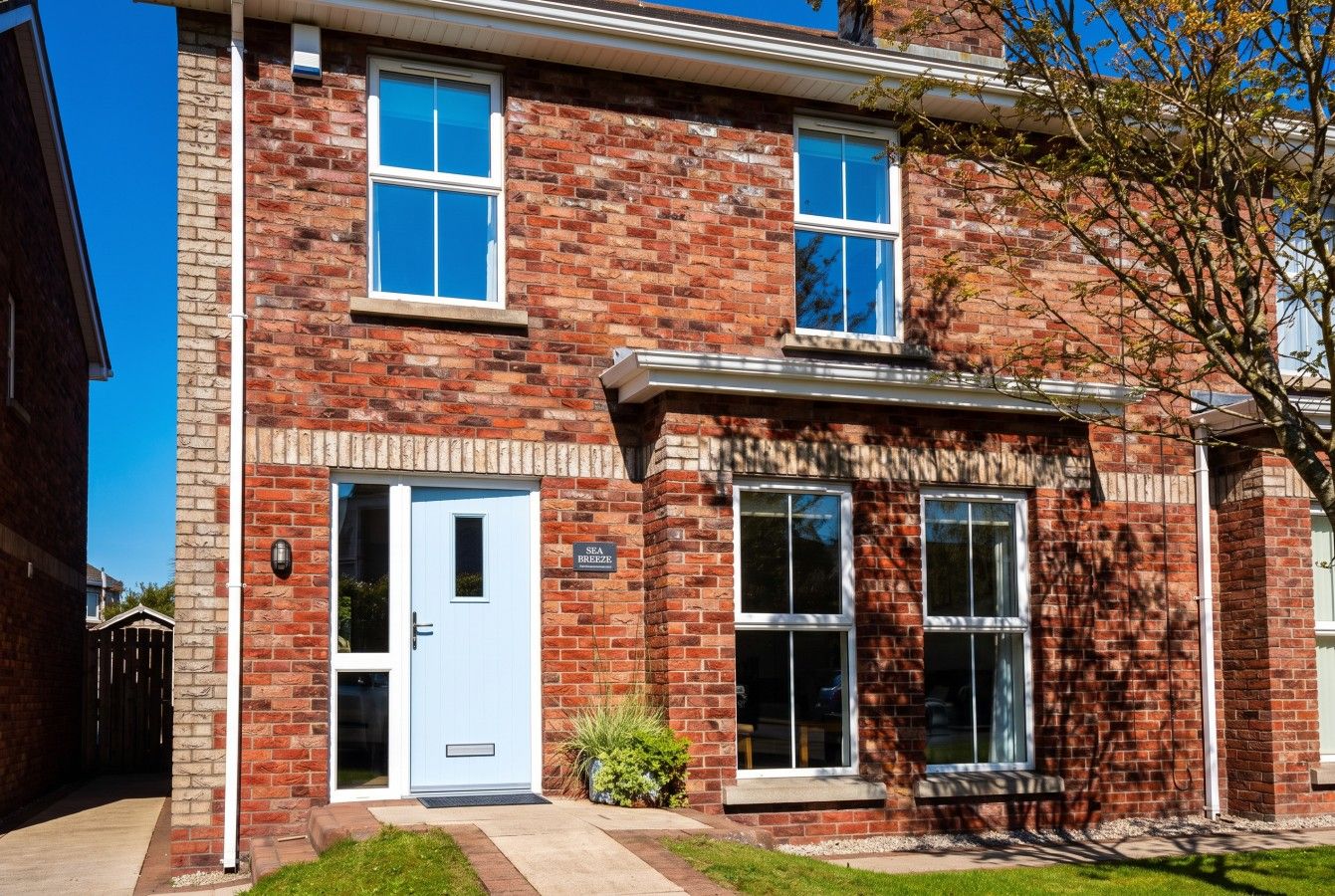 A two-story brick building with a white door and windows.