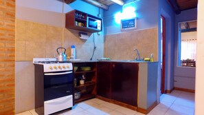 Una cocina compacta con estufa a gas, horno y una pequeña encimera.