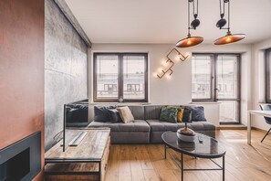 Uma sala de estar moderna com um sofá, uma mesa de centro e uma lareira.