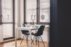 Uma sala de jantar com mesa, cadeiras e uma garrafa de vinho.