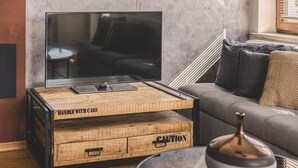 A modern living room with a flat-screen TV on a wooden coffee table, a sofa, and a decorative vase. - Dream 30 | Duży Loft z 2 Sypialniami | Bydgoszcz (Bydgoszcz)