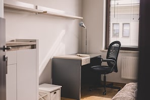 A compact bedroom with a bed, a desk, and a chair. - Dream 30 | Duży Loft z 2 Sypialniami | Bydgoszcz (Bydgoszcz)