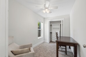 A room with a ceiling fan, a window, a door leading to a closet, a table, and a chair. - Comfortable coastal living just minutes from Historic Downtown Panama City (Panama City)