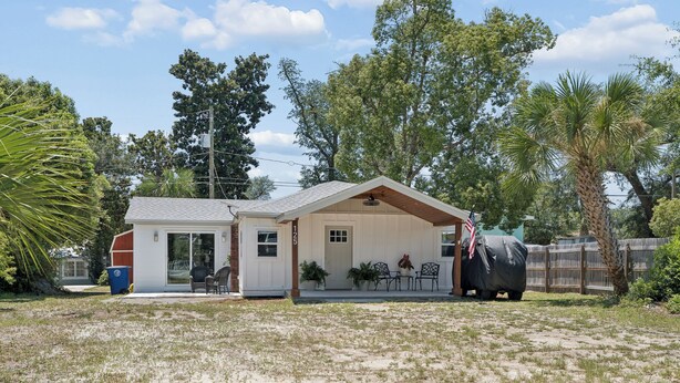 A single-story house with a covered porch, a garage, and a fenced yard. - Comfortable coastal living just minutes from Historic Downtown Panama City (Panama City)