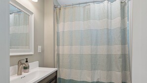 A bathroom with a shower curtain, a sink, and a mirror. - Comfortable coastal living just minutes from Historic Downtown Panama City (Panama City)