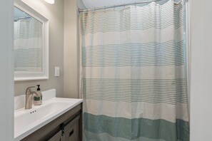 A bathroom with a shower curtain, a sink, and a mirror. - Comfortable coastal living just minutes from Historic Downtown Panama City (Panama City)