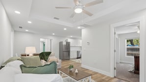 A modern living room with a white sofa, a coffee table, and a ceiling fan. - Comfortable coastal living just minutes from Historic Downtown Panama City (Panama City)