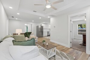 A modern living room with a white sofa, a coffee table, and a ceiling fan. - Comfortable coastal living just minutes from Historic Downtown Panama City (Panama City)