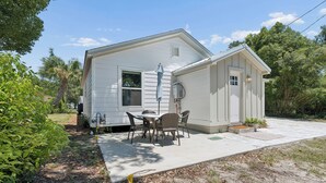 A small white house with a patio area featuring a table and chairs. - Comfortable coastal living just minutes from Historic Downtown Panama City (Panama City)