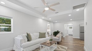 A modern living room with a white sofa, a wooden coffee table, and a ceiling fan. - Comfortable coastal living just minutes from Historic Downtown Panama City (Panama City)