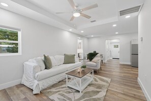 A modern living room with a white sofa, a wooden coffee table, and a ceiling fan. - Comfortable coastal living just minutes from Historic Downtown Panama City (Panama City)