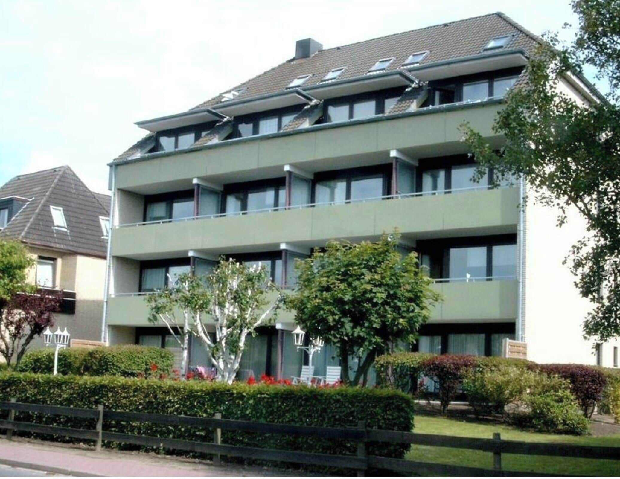Ein mehrgeschossiges Gebäude mit flachem Dach und großen Fenstern.