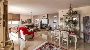 Un salón amplio con sofá, sillón y mesa de comedor.