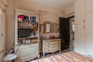 A bedroom with a bed, a vanity with a mirror, a television on a stand, and a wardrobe. - Apartment 'Villa Neraida - Panoramic Lake View' with Lake View, Wi-Fi and Air Conditioning (Νεράιδα)