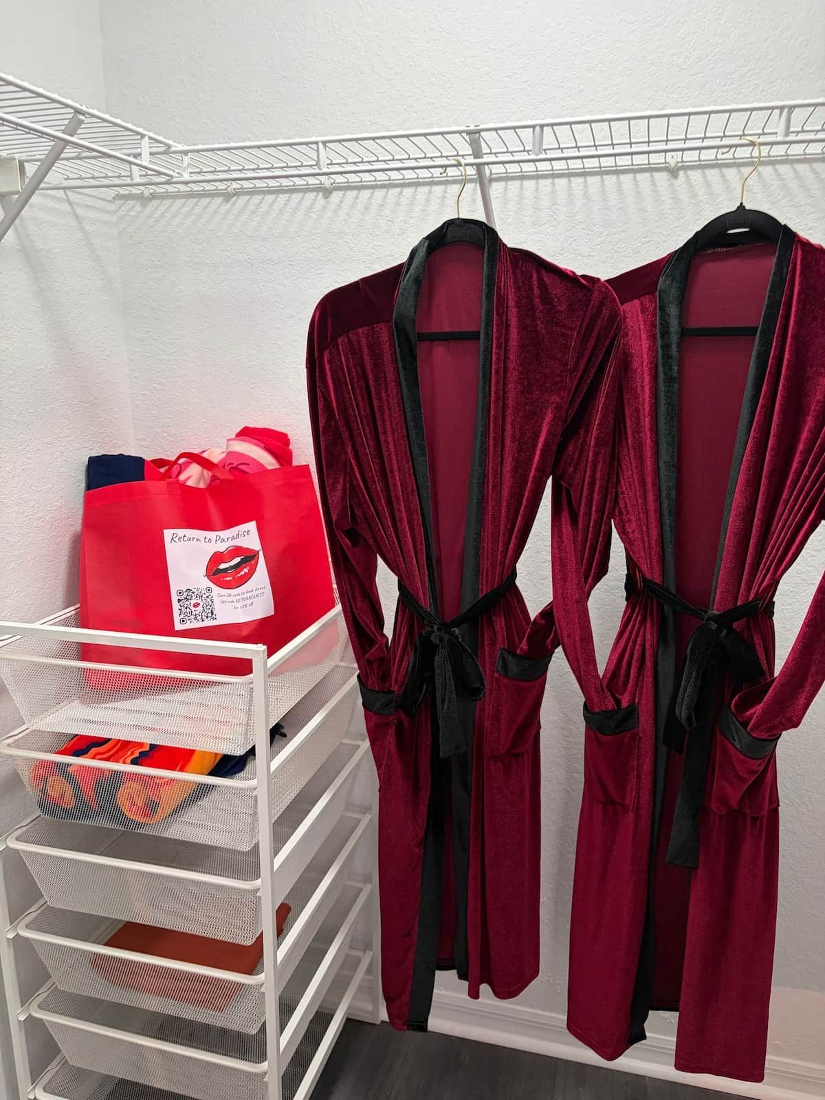 A storage rack with folded clothes and a red bag with a QR code.
