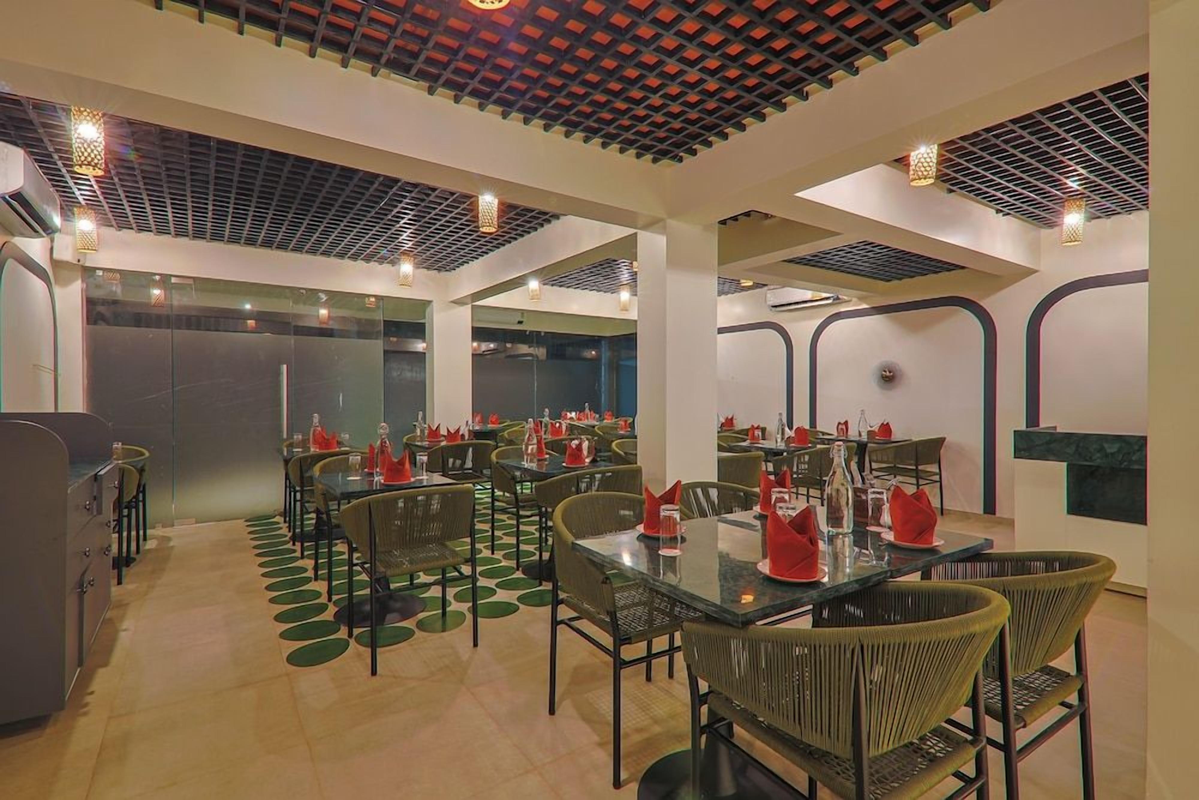 A restaurant with multiple tables and chairs, a patterned ceiling, and a modern design.