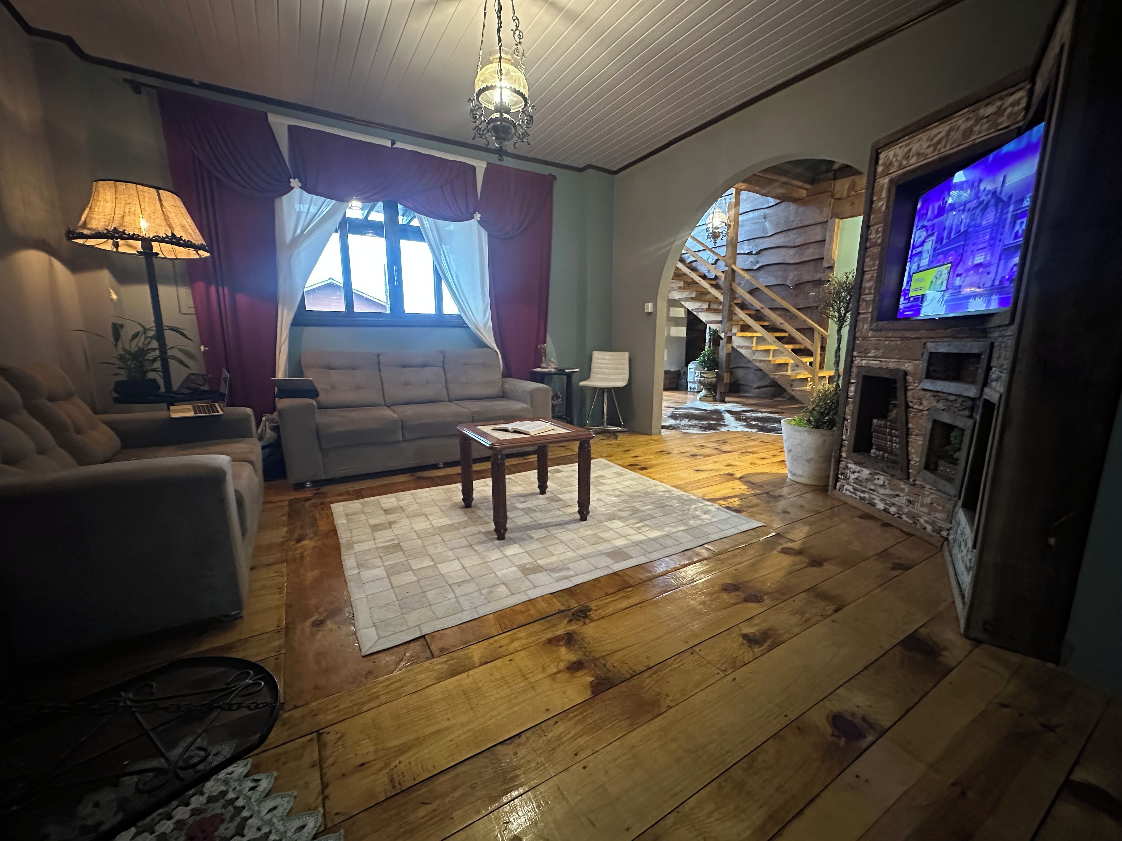 A living room with a sofa, armchair, coffee table, and a television.