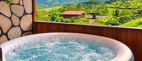 A hot tub with a view of a mountainous landscape.