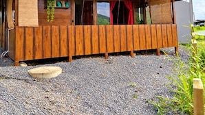 Una cabana de fusta amb teulada inclinada, un porxo davanter i un camí de grava.