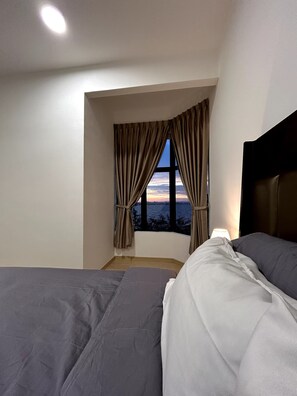 A hotel room with a large window, two beds, a nightstand, and a lamp. - 2BR: Twynstar Mutiara | Spacious 2BR Beachfront Family Stay (Tanjung Kling)