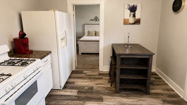Una cocina compacta con estufa, refrigerador y una pequeña mesa de comedor.