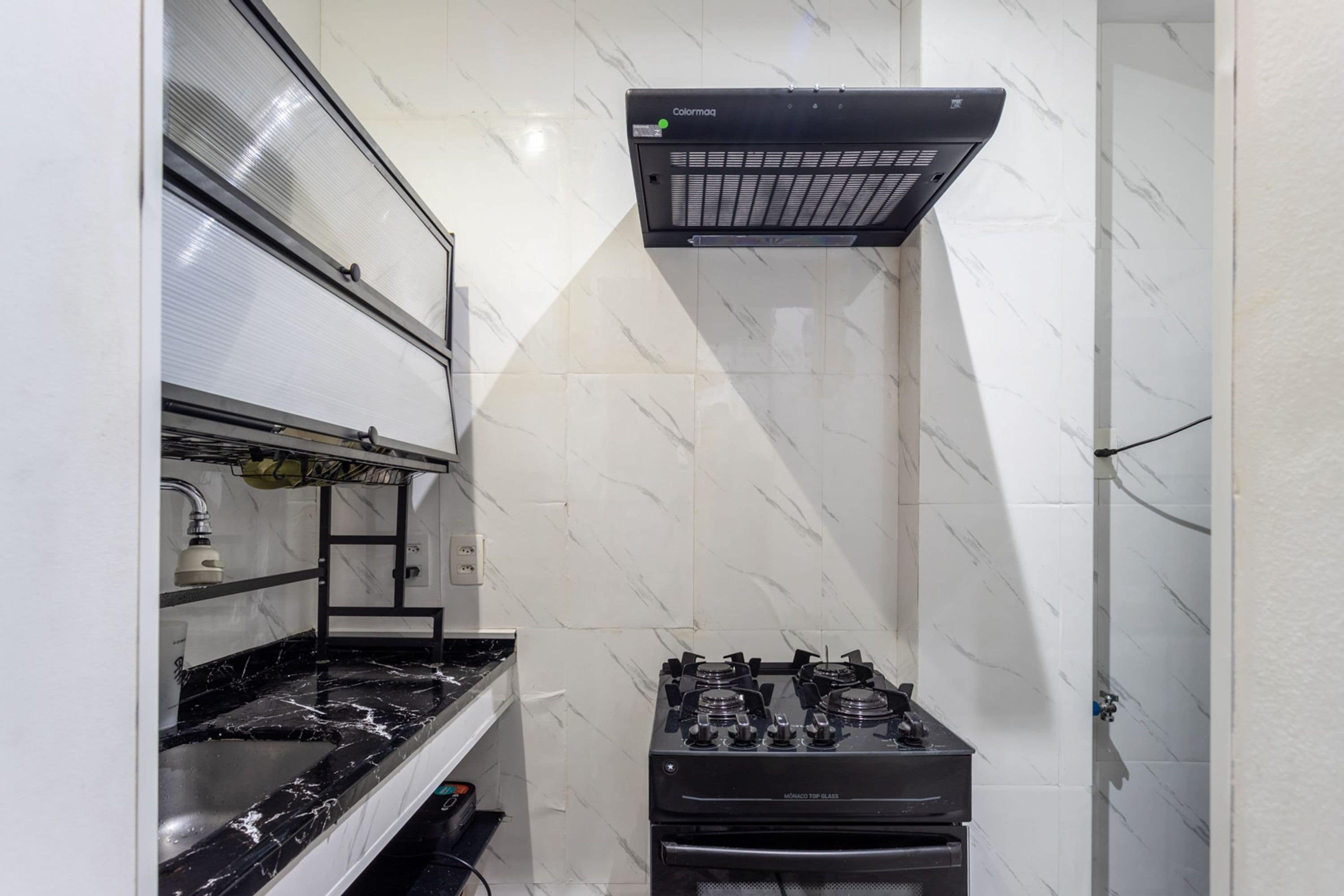 A kitchen with a gas stove, a range hood, and a built-in oven.